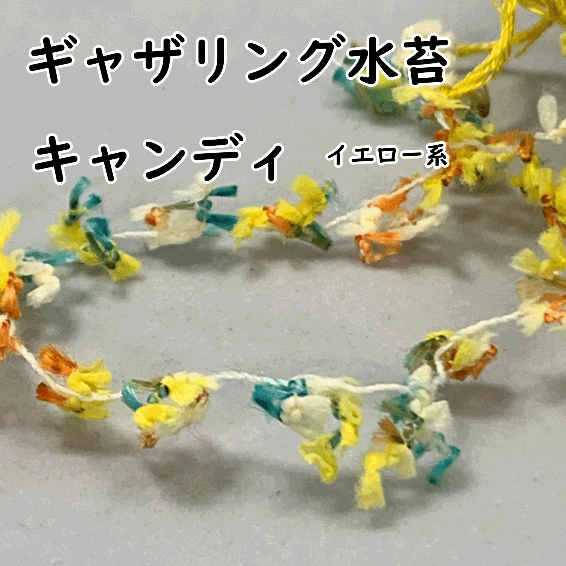 花創人ネットショップで販売するギャザリング水苔【ギャザモス】キャンディ・イエロー系。黄色・白・オレンジ・ブルーグリーンなどが混ざるカラフルな糸を伸ばした商品画像で、細かなモール状の質感と色の切り替わりが分かります。プランツギャザリングのユニット作りや苔玉、ルーティブーケの化粧巻き、作品のアクセントに使うアクリル製のギャザリング用資材です。
