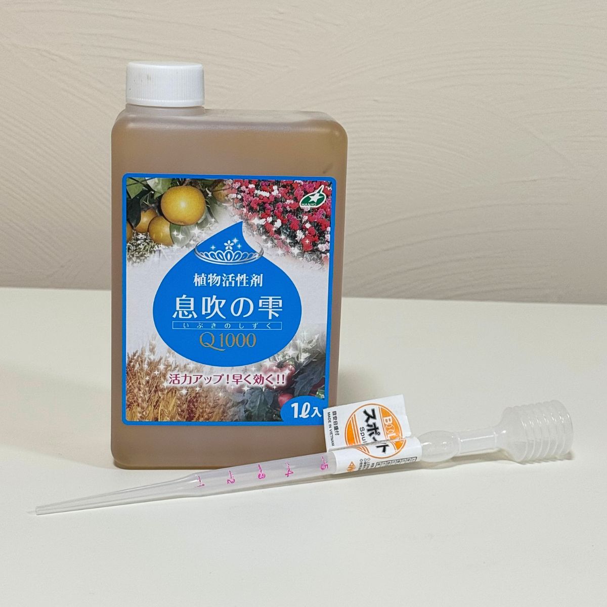 花創人で販売する植物活性剤「息吹の雫Q1000」1Lと計量スポイト。スポイトには1mlごとに目盛りがあり、一度に5mlまで計量できます。水で希釈して使う息吹の雫を手軽に量れるため、草花、花苗、野菜、果樹、観葉植物などの管理に便利です。花創人のネットショップではスポイト付き商品も選べます。