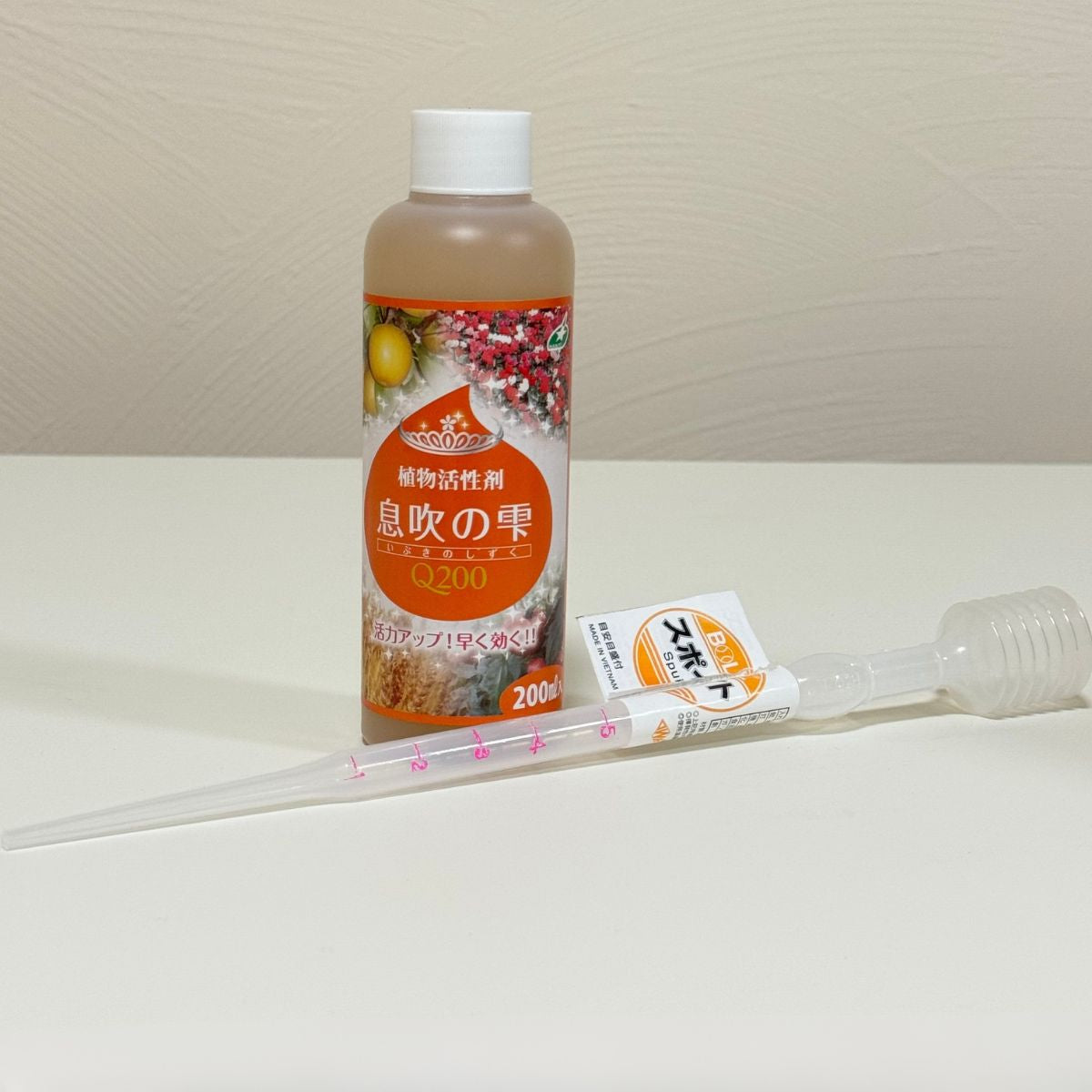 花創人で販売する植物活性剤「息吹の雫Q200」200mlと計量スポイト。スポイトには1mlごとに目盛りがあり、一度に5mlまで計量できます。水で希釈して使う息吹の雫を手軽に量れるため、草花、花苗、野菜、果樹、観葉植物などの管理に便利です。花創人のネットショップではスポイト付き商品も選べます。