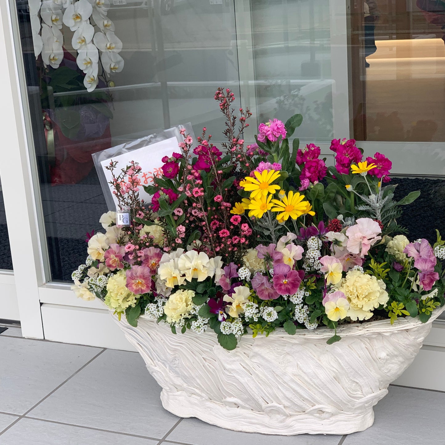 店舗前に飾られた開店祝いのギャザリング寄せ植え 花創人ガーデニング教室