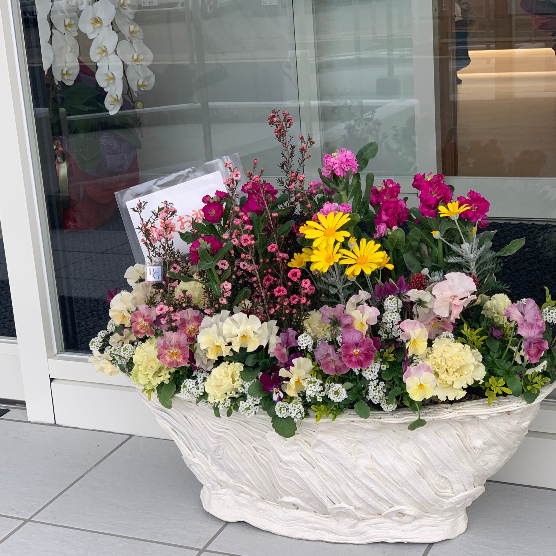 店舗前に飾られた開店祝いのギャザリング寄せ植え 花創人ガーデニング教室