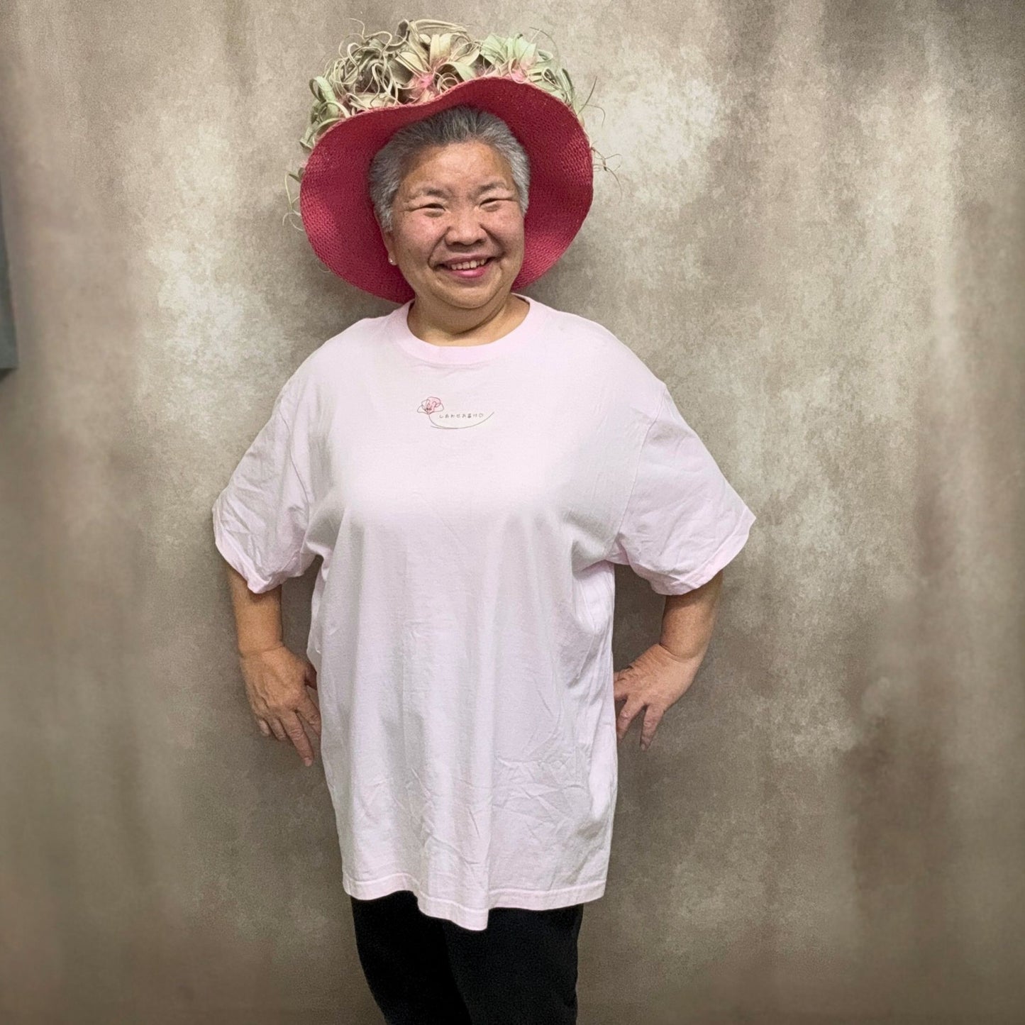 しあわせお届けTシャツ半袖の着用例で、オゼジュン先生がXXLサイズを前から着用した全身画像、やわらかなピンク色が伝わるゆったりシルエットのTシャツ、花創人ガーデニング教室